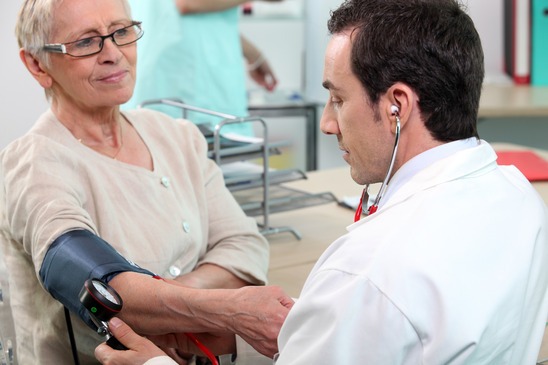 Doctor checking the blood pressure of an elderly lady